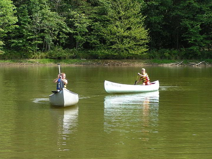 boys wearing lifevests in canoes